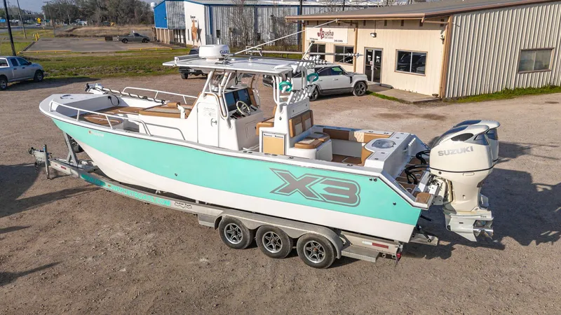 Slide: The Image of 2019 Shallow Sport 32 X3 boat on trailer, featuring Suzuki outboard engines. - 2
