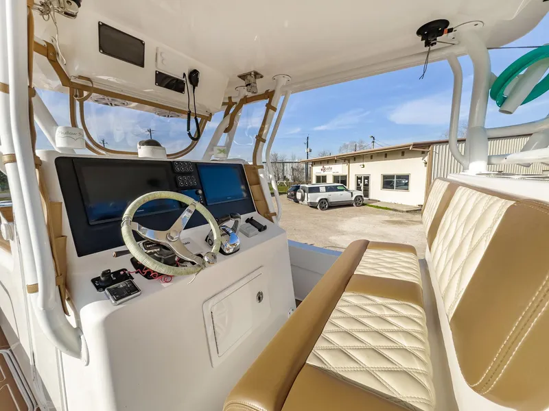 Slide: The Image of 2019 Shallow Sport 32 X3 boat interior with steering wheel and navigation screens. - 20