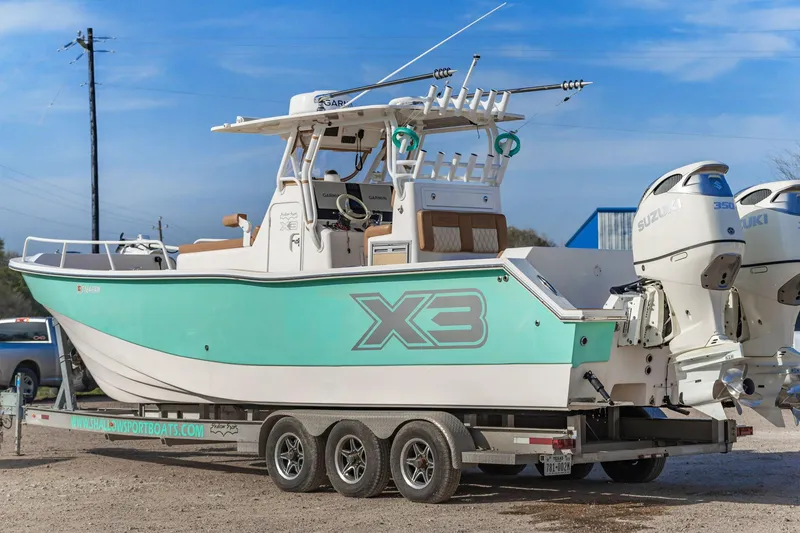 Slide: The Image of 2019 Shallow Sport 32 X3 boat on trailer, featuring dual outboard engines. - 7