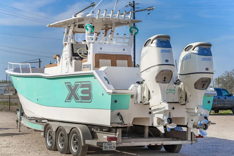 Slide: The Image of 2019 Shallow Sport 32 X3 boat on trailer with dual engines, parked outdoors. - 8