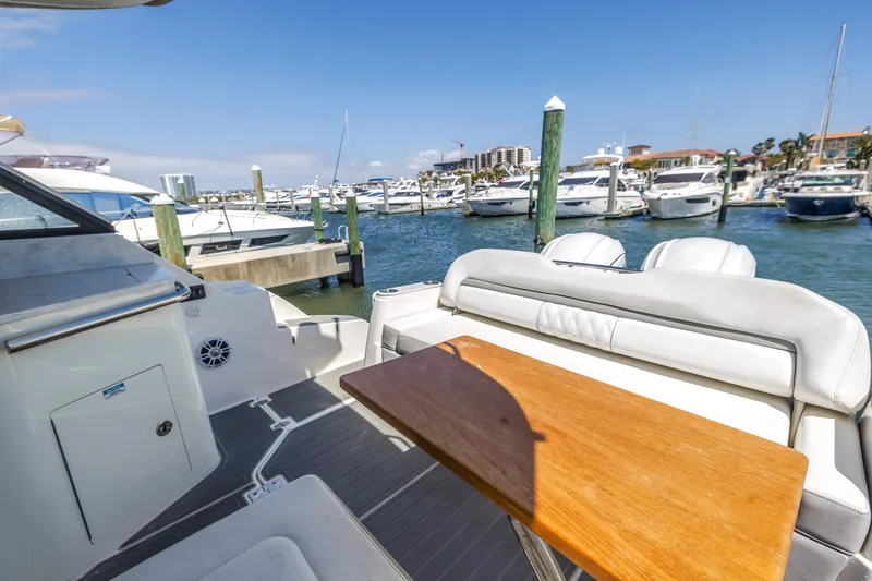 Slide: The Image of 2022 Regal 36 XO yacht interior with wooden table, docked at marina. - 10