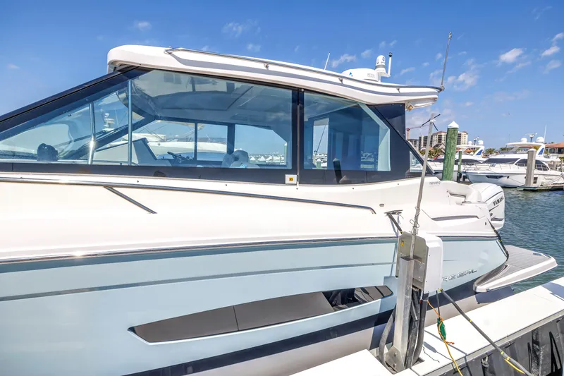 Slide: The Image of 2022 Regal 36 XO yacht docked at marina under clear blue sky. - 2