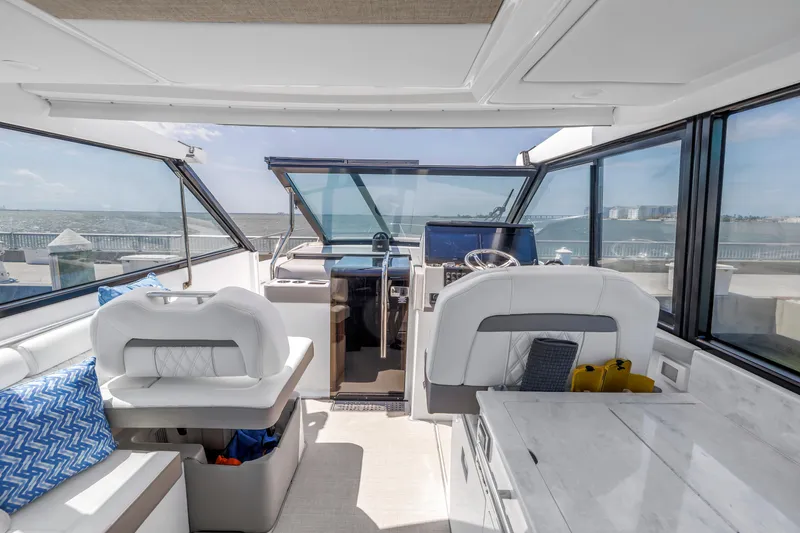 Slide: The Image of 2022 Regal 36 XO yacht interior with modern helm, seating, and panoramic windows. - 22