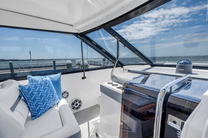 Slide: The Image of 2022 Regal 36 XO yacht interior with plush seating and ocean view. - 25