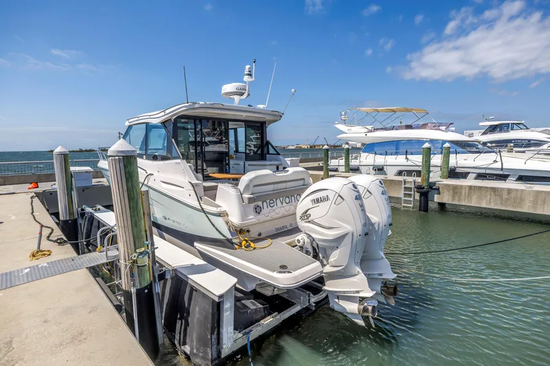 Slide: The Image of 2022 Regal 36 XO boat docked with Yamaha engines, clear sky, and marina view. - 3