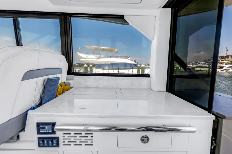 Slide: The Image of Interior view of 2022 Regal 36 XO yacht with sleek white surfaces and marina backdrop. - 39