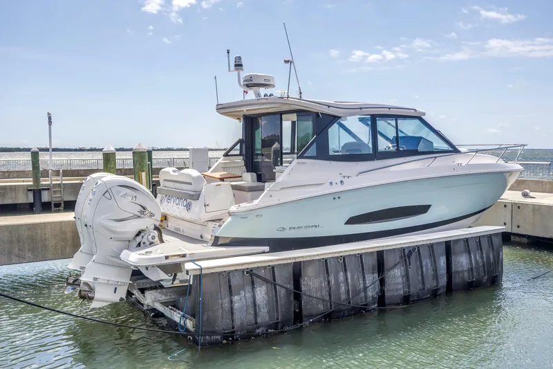 Slide: The Image of 2022 Regal 36 XO boat docked at marina, featuring sleek design and powerful outboard engines. - 4