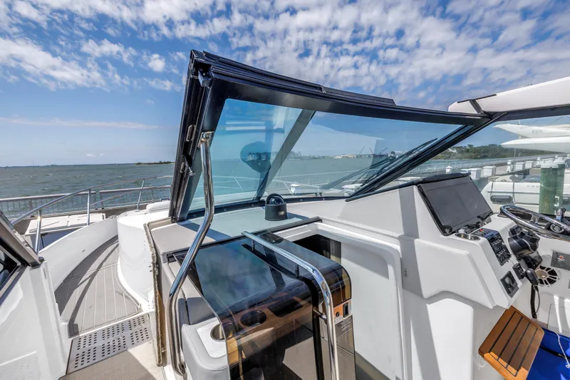 Slide: The Image of 2022 Regal 36 XO yacht helm with modern controls and ocean view. - 6