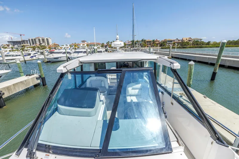 Slide: The Image of 2022 Regal 36 XO boat docked at a marina with clear blue skies. - 8