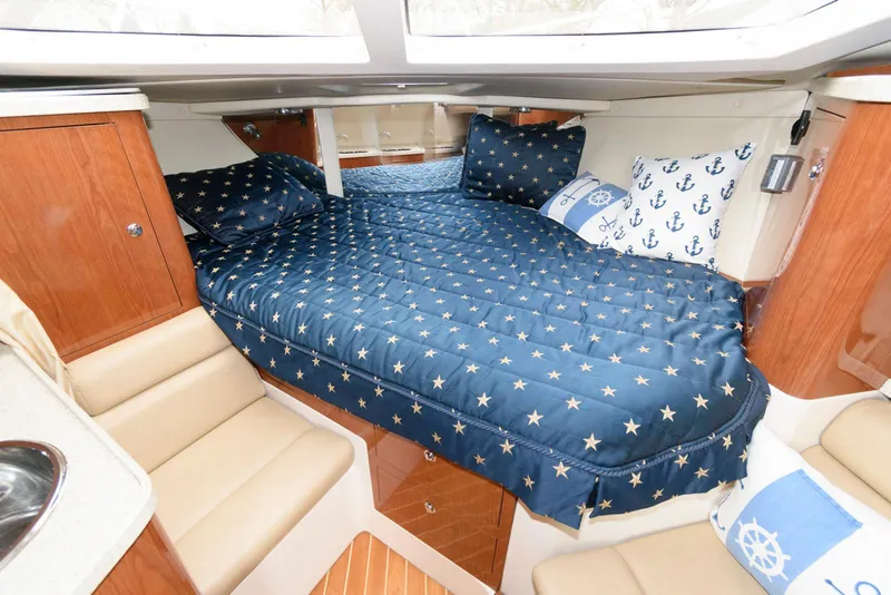 Slide: The Image of 2007 Regal 3360 Window Express cabin with star-patterned bedding and nautical-themed decor. - 13