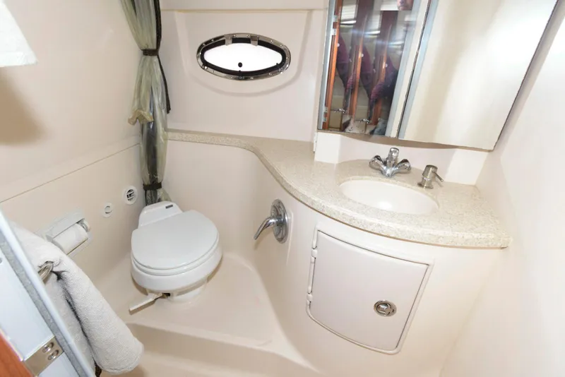 Slide: The Image of 2007 Regal 3360 Window Express bathroom with sink, toilet, and porthole window. - 16