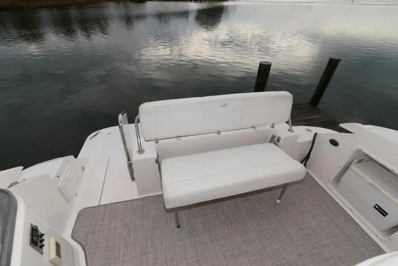 Slide: The Image of 2007 Regal 3360 Window Express boat with white seating, docked by calm water. - 3