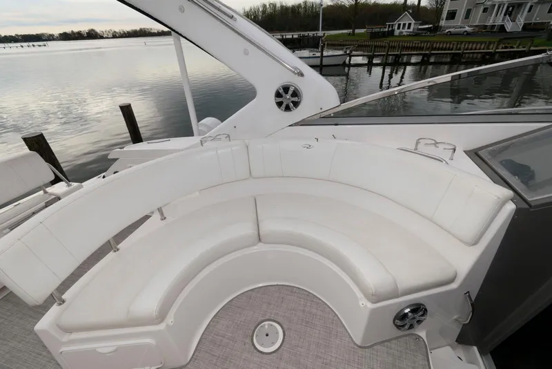 Slide: The Image of 2007 Regal 3360 Window Express boat with white seating, docked by a serene waterfront. - 6
