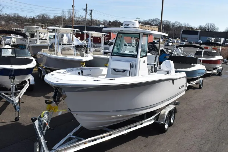 The Image of 2025 Blackfin 252CC boat on trailer, displayed in a marina with other boats. - 1