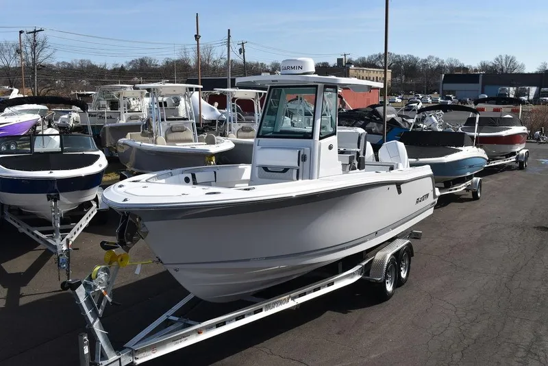 Slide: The Image of 2025 Blackfin 252CC boat on trailer in marina, surrounded by other boats. - 2
