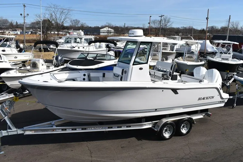 Slide: The Image of 2025 Blackfin 252CC boat on trailer, displayed in a marina setting. - 3