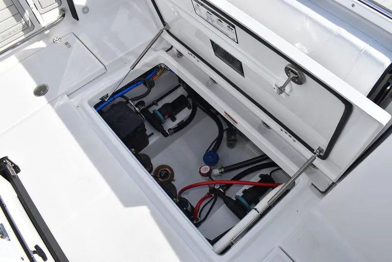 Slide: The Image of 2025 Blackfin 252CC boat storage compartment with visible wiring and components. - 32