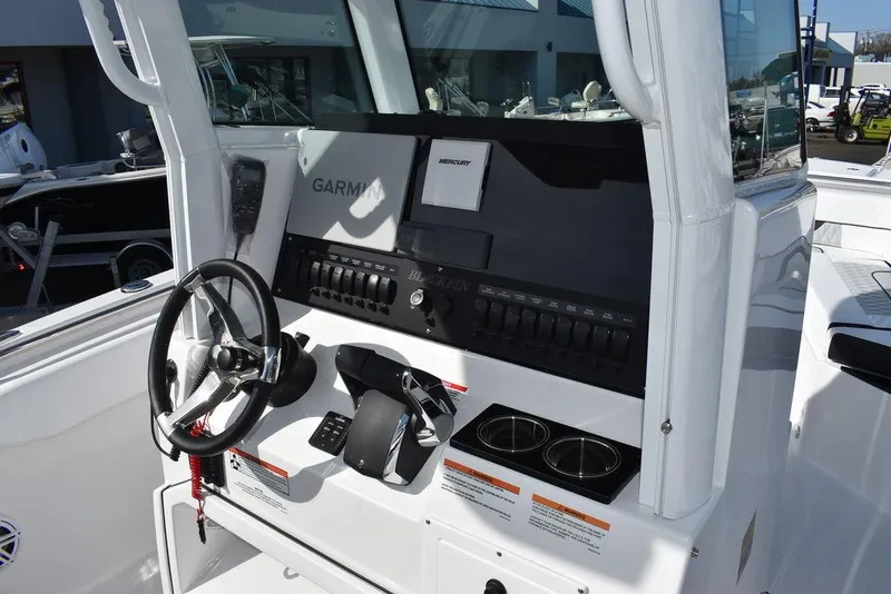 Slide: The Image of 2025 Blackfin 252CC boat dashboard with Garmin and Mercury controls. - 43