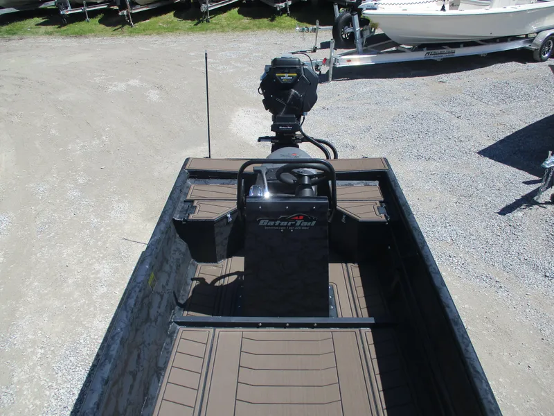 Slide: The Image of 2025 Gator Tail 1860 Extreme CC boat with center console and motor, parked on gravel. - 6