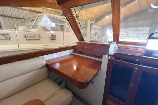 Slide: The Image of Interior of 2001 Little Harbor WhisperJet 44 with wooden desk and beige seating. - 12