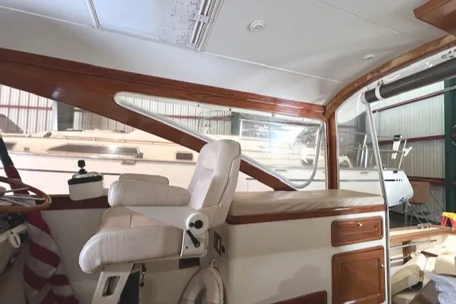Slide: The Image of 2001 Little Harbor WhisperJet 44 interior with wooden accents and captain's chair in a boatyard. - 13