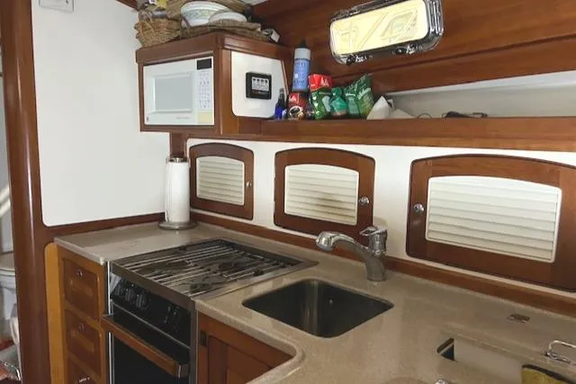 Slide: The Image of 2001 Little Harbor WhisperJet 44 yacht kitchen with stove, sink, and storage cabinets. - 20