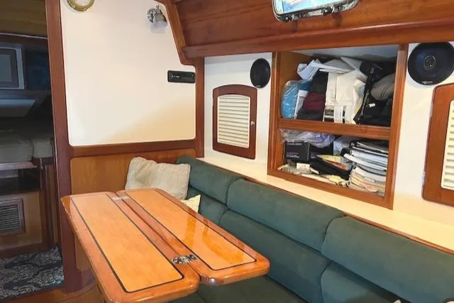 Slide: The Image of Interior of 2001 Little Harbor WhisperJet 44 with wooden table and green seating. - 24