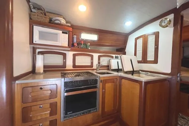 Slide: The Image of 2001 Little Harbor WhisperJet 44 yacht kitchen with wooden cabinetry, stove, and microwave. - 26