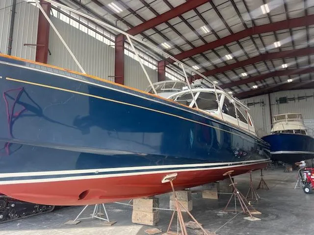 Slide: The Image of 2001 Little Harbor WhisperJet 44 boat in storage, blue hull, red bottom, indoor facility. - 5