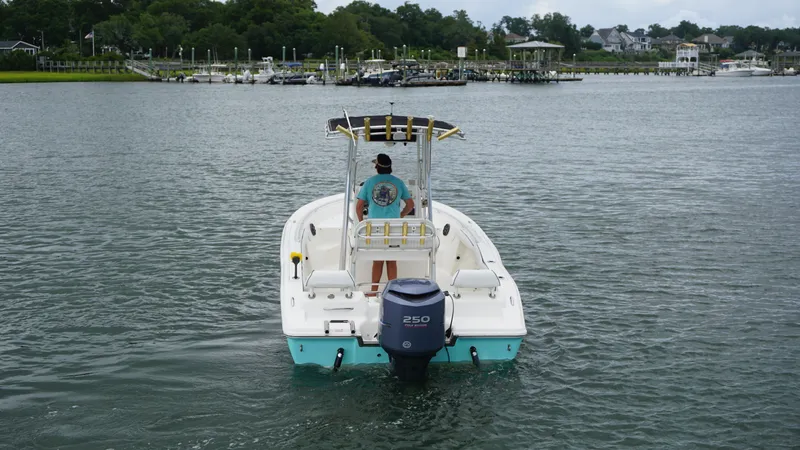 Slide: The Image of 2008 Key West 211 Bluewater boat on calm water with a person at the helm. - 2