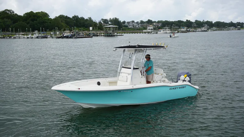 Slide: The Image of 2008 Key West 211 Bluewater boat on calm water with a person at the helm. - 3