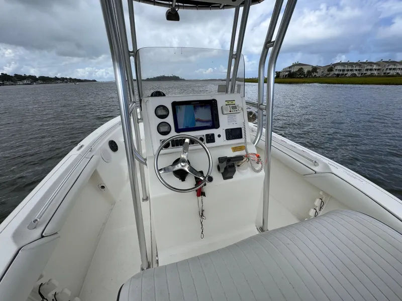 Slide: The Image of 2008 Key West 211 Bluewater boat dashboard with steering wheel on a calm waterway. - 5