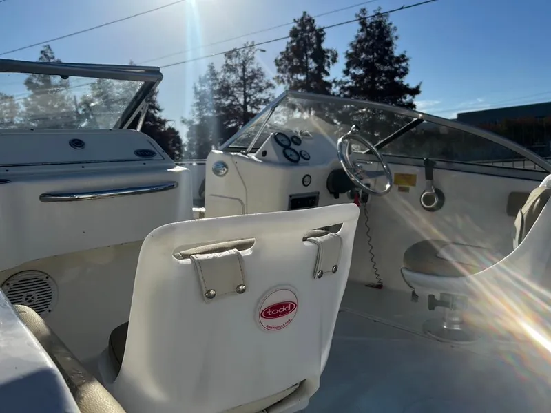 Slide: The Image of 2018 Key West 186 DC boat interior with steering wheel and seating, sunlight streaming in. - 11