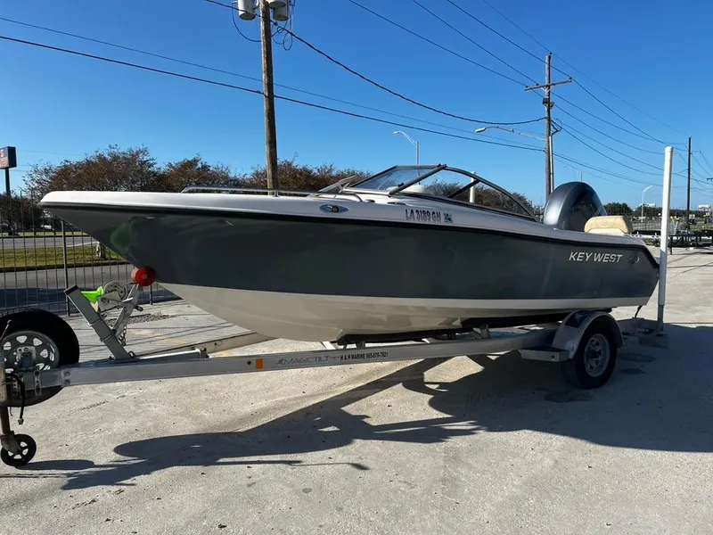 Slide: The Image of 2018 Key West 186 DC boat on trailer, parked outdoors under clear blue sky. - 5