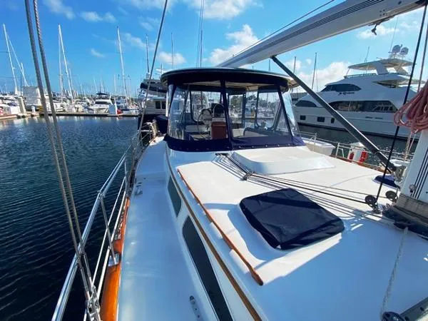Slide: The Image of 1989 Irwin 54 yacht docked at marina, featuring spacious deck and clear blue sky. - 10