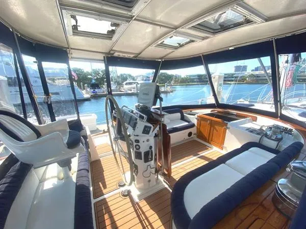 Slide: The Image of 1989 Irwin 54 yacht interior with helm, seating, and panoramic windows overlooking marina. - 19