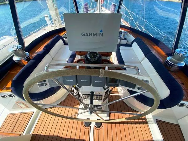 Slide: The Image of Cockpit of 1989 Irwin 54 yacht with Garmin navigation, wooden deck, and cushioned seating. - 30