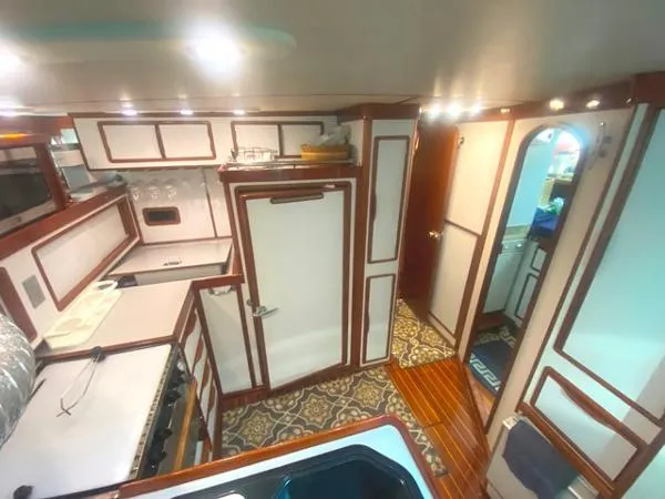 Slide: The Image of Interior of 1989 Irwin 54 yacht, featuring a well-equipped kitchen and elegant wood accents. - 39