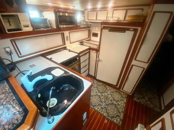 Slide: The Image of Luxurious 1989 Irwin 54 yacht kitchen with modern appliances and elegant wood finishes. - 40