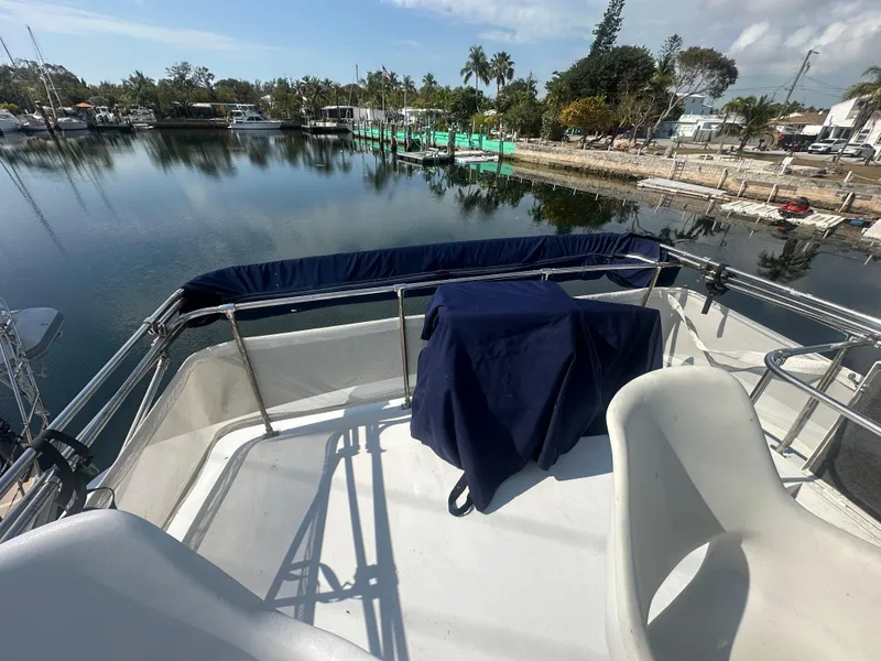 Slide: The Image of 1974 Bertram 42 Motor Yacht deck view, overlooking calm marina waters and shoreline. - 18