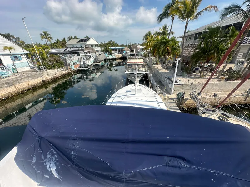 Slide: The Image of 1974 Bertram 42 Motor Yacht docked in a scenic marina with palm trees and clear skies. - 19