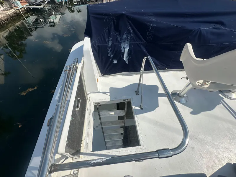 Slide: The Image of 1974 Bertram 42 Motor Yacht deck with open hatch and covered seating area. - 22