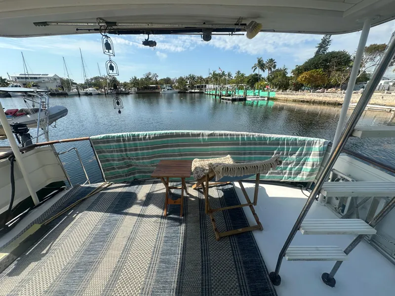 Slide: The Image of 1974 Bertram 42 Motor Yacht deck with chairs, table, and waterfront view. - 34
