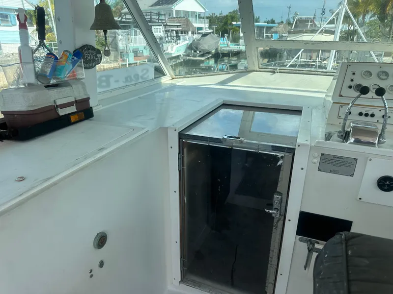 Slide: The Image of 1974 Bertram 42 Motor Yacht cockpit with control panel and storage area. - 37