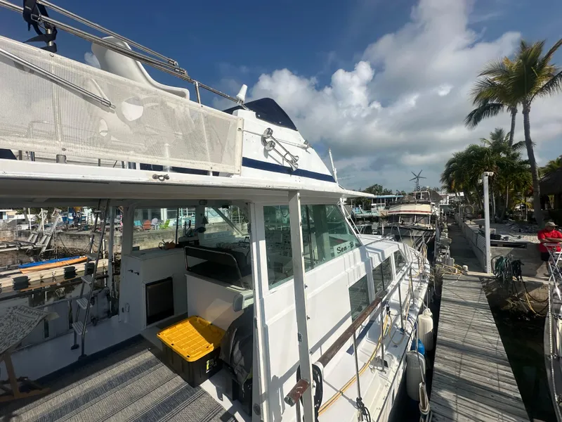 Slide: The Image of 1974 Bertram 42 Motor Yacht docked under a clear blue sky. - 7