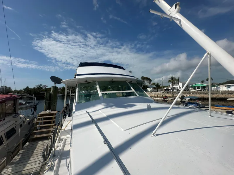 Slide: The Image of 1974 Bertram 42 Motor Yacht docked under a clear blue sky. - 9