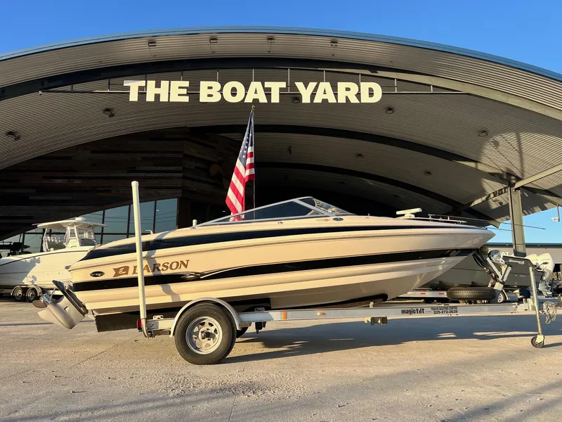 Slide: The Image of 2002 Larson LXi 190 boat on trailer at The Boat Yard, with American flag. - 1