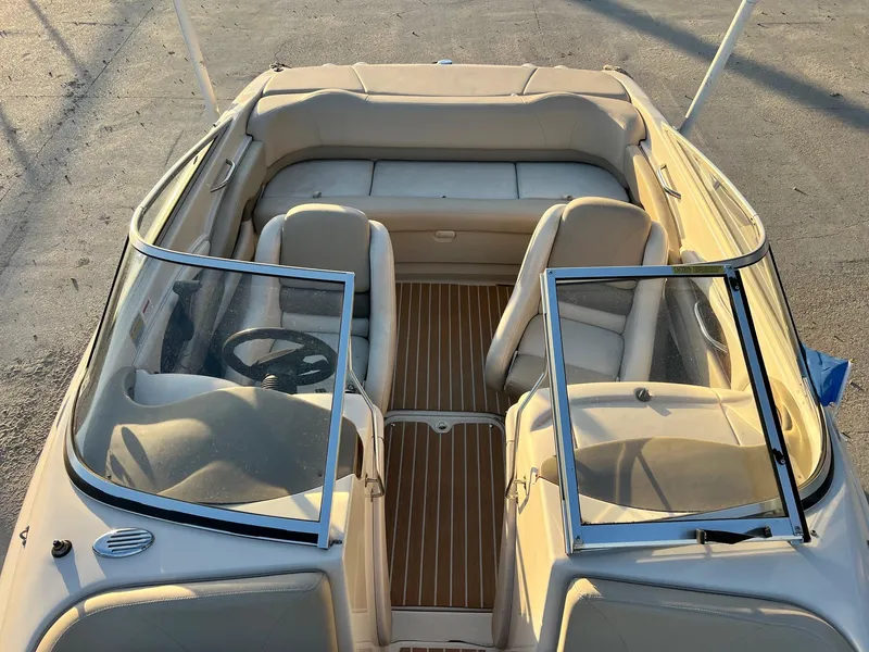 Slide: The Image of 2002 Larson LXi 190 boat interior with beige seating and wooden flooring. - 11