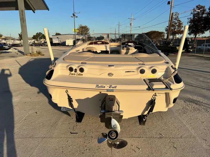 Slide: The Image of 2002 Larson LXi 190 boat, rear view, parked outdoors in a marina setting. - 7