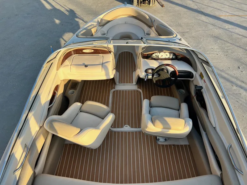 Slide: The Image of 2002 Larson LXi 190 boat interior with beige seating and wood-patterned flooring. - 8